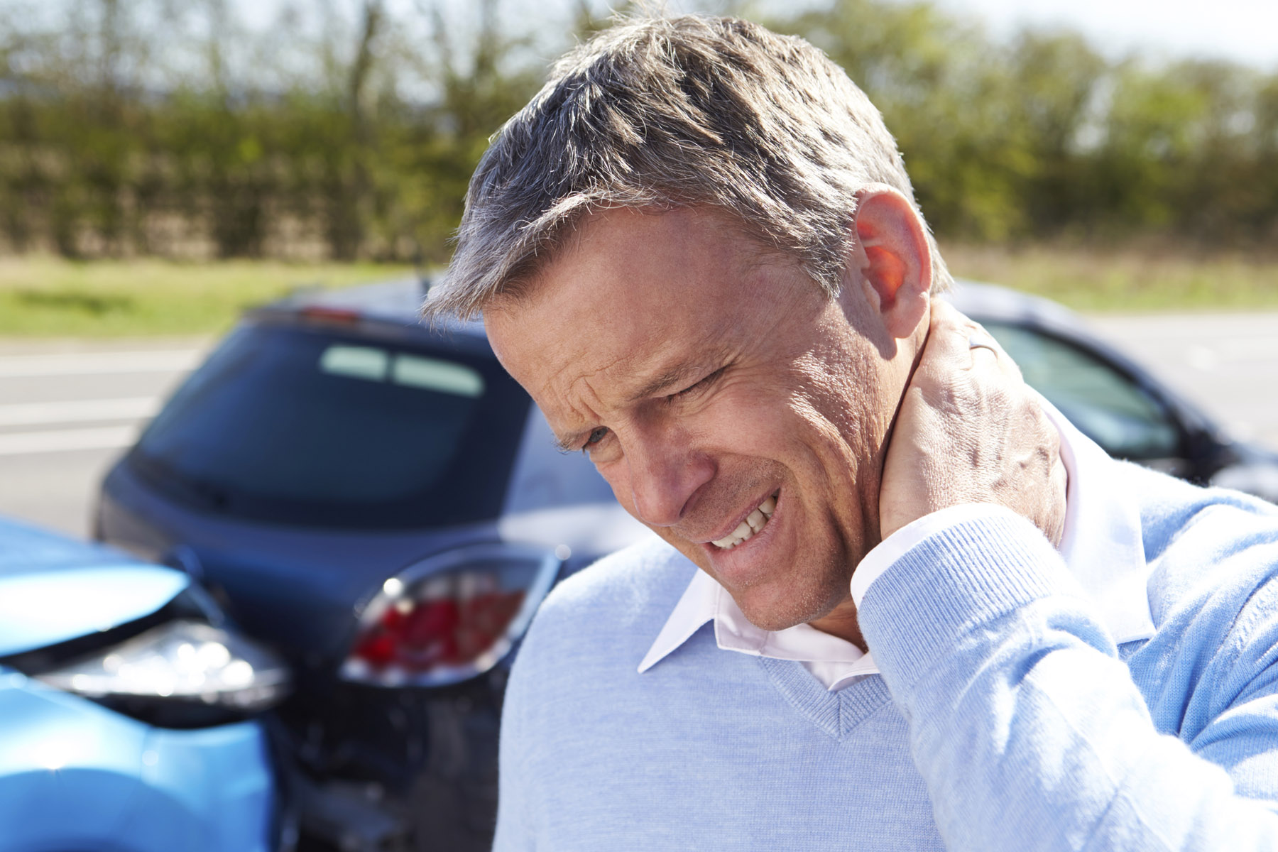 man holding his neck due to a car accident